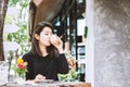 Beautiful Asian woman drinking coffee outdoors sitting at coffee shop Royalty Free Stock Photo