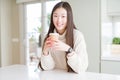 Beautiful Asian woman drinking a coffee in a take away paper cup with a happy face standing and smiling with a confident smile Royalty Free Stock Photo