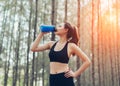Beautiful asian woman drinking cool water bottle in the forest Royalty Free Stock Photo