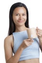 Asian Woman drinking a Healthy Tan Mug of Hot Tea Royalty Free Stock Photo