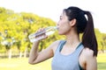 Beautiful Asian woman drinking water. She exercises in an outdoor park. Royalty Free Stock Photo