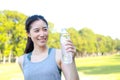 Beautiful Asian woman drinking water. She exercises in an outdoor park. Royalty Free Stock Photo