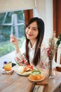 Beautiful asian woman eating delicious  waffles in coffee shop cafe Royalty Free Stock Photo