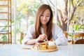 A woman eating ice cream with a mixed berries pancakes and whipped cream by wooden spoon Royalty Free Stock Photo