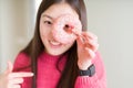 Beautiful Asian woman eating pink sugar donut with surprise face pointing finger to himself Royalty Free Stock Photo