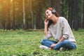 A beautiful asian woman enjoy listening to music with headphone with feeling happy and relaxed in the park Royalty Free Stock Photo