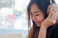 A beautiful Asian woman enjoy listening to music with headphone in modern cafe with feeling relax and happy Royalty Free Stock Photo