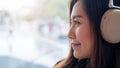 A beautiful Asian woman enjoy listening to music with headphone in modern cafe with feeling relax and happy Royalty Free Stock Photo