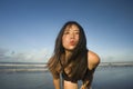 Beautiful Asian woman enjoying sand and sea - young happy and attractive Korean girl in bikini having fun at tropical beach during Royalty Free Stock Photo