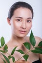 Beautiful asian woman face portrait with green leaf . Concept for skin care or organic cosmetics Royalty Free Stock Photo