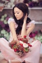 Beautiful asian woman florist in pink dress with bouquet of flowers in hands in flower store Royalty Free Stock Photo