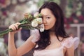 Beautiful asian woman florist in pink dress with bouquet of flowers in hands in flower store Royalty Free Stock Photo