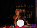 Beautiful Asian woman fortune teller using crystal ball on red table to forecast future