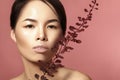 Beautiful asian woman with fresh daily makeup. Vietnamese beauty girl in spa treatment with green leafs near face Royalty Free Stock Photo
