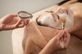 Beautiful Asian Woman getting facial nourishing at spa salon.