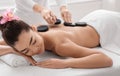 Beautiful asian woman getting massage with hot stones at modern spa salon Royalty Free Stock Photo