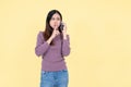 A beautiful Asian woman is gossiping or telling a secret to her friend over the phone Royalty Free Stock Photo