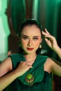 a beautiful Asian woman in a green dress is posing with her hands very gracefully and has green eyes Royalty Free Stock Photo