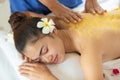 Beautiful Asian woman having exfoliation treatment with body scrub in spa salon, scrubbing and skin care concept, enjoying and Royalty Free Stock Photo