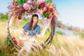 Beautiful Asian woman having relax time on a flower swing in nature field for nature hapiness lifestyle