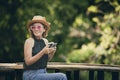 beautiful asian woman holdin smart phone and cup of coffee sitting at home terrace