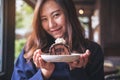 A beautiful asian woman holding chocolate cake roll and whipped cream with feeling happy and good lifestyle Royalty Free Stock Photo