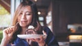 A beautiful Asian woman holding chocolate cake roll and whipped cream and fork with feeling happy and enjoy eating in the cafe Royalty Free Stock Photo