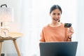 Beautiful Asian woman holding credit card and using digital laptop with shopping online. Royalty Free Stock Photo