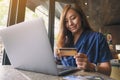A woman holding credit cards while using laptop computer Royalty Free Stock Photo