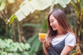 A beautiful asian woman holding and drinking hot coffee in the outdoors Royalty Free Stock Photo