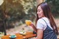 A beautiful asian woman holding and drinking hot coffee in the outdoors Royalty Free Stock Photo