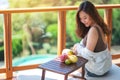 A beautiful asian woman holding fruits while enjoy sitting at balcony Royalty Free Stock Photo