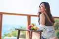 A beautiful asian woman holding fruits while enjoy sitting at balcony Royalty Free Stock Photo