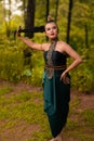 Beautiful Asian woman holding her black hair while standing in front of the forest in a green costume Royalty Free Stock Photo