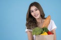 Beautiful Asian woman holding paper shopping bag full of vegetables and groceries Royalty Free Stock Photo