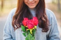 A beautiful asian woman holding red roses flower with feeling happy on Valentine`s day Royalty Free Stock Photo