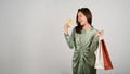 A beautiful Asian woman holding shopping bag and credit card in her hands, shopping concept Royalty Free Stock Photo