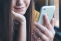 A beautiful Asian woman holding , using and looking at smart phone in cafe Royalty Free Stock Photo