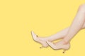 Beautiful Asian Woman Legs Wearing Summer Beige High Heels Shoes Isolated On Yellow Background with Clipping Path. Side View of Royalty Free Stock Photo