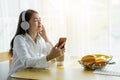 A beautiful Asian woman is listening to music happily in her home Royalty Free Stock Photo