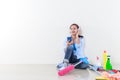 Beautiful asian woman is listening to music in her earphones as she sits and rests after cleaning her house, and there is cleaning