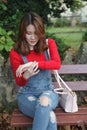 Beautiful Asian woman with long hair on a bench looking at her watch Royalty Free Stock Photo