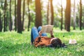 A woman lying and reading a book in the park