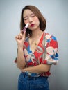 Beautiful Asian woman after makeup smile and show three in one lipstick create over lips , eyeshadow and blush onestop in cosmetic Royalty Free Stock Photo