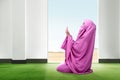 Beautiful asian woman in pink veil sitting in praying position and raise the hands on the carpet inside the room Royalty Free Stock Photo