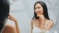Beautiful Asian Woman Plays and Admires Her Perfect Soft Skin and Lush Black Hair, Looks at Camera Royalty Free Stock Photo