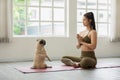 Beautiful Asian woman practice yoga lotus pose with dog pug breed enjoy and relax Royalty Free Stock Photo