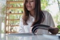 A beautiful Asian woman reading a book in white modern cafe Royalty Free Stock Photo