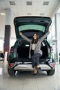 Beautiful asian woman rejoices in a new car