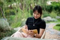 A beautiful Asian woman relaxing in a beautiful green backyard and writing her diary at a table Royalty Free Stock Photo